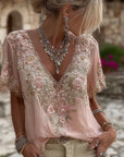 Kirelina - Feminin bluse med broderede blomster og elegant V-hals